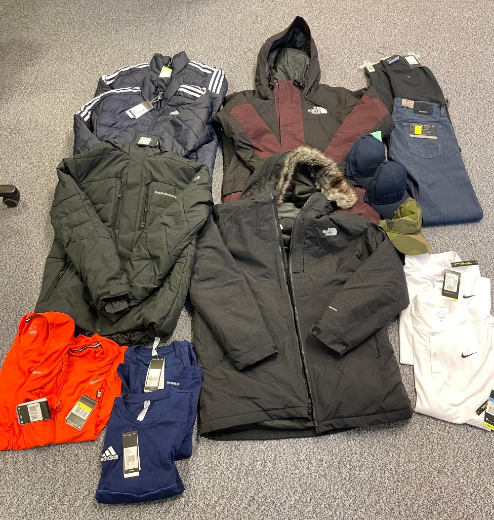 Vaatteita lattialla, toppatakkeja, teknisiä urheilupaitoja, kenkiä, Luhta-merkkiset kengät sekä Halti-merkkiset kengät.