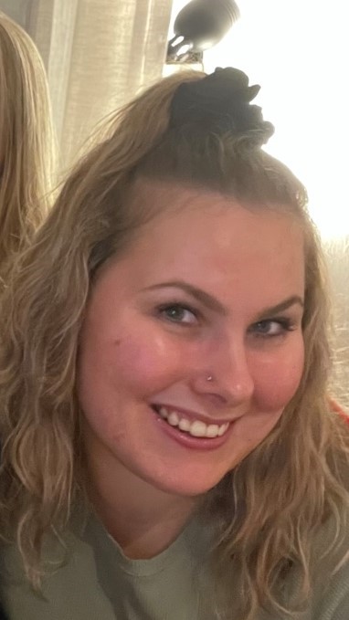 Nainen, jolla on vaaleat hiukset, hymyilee.