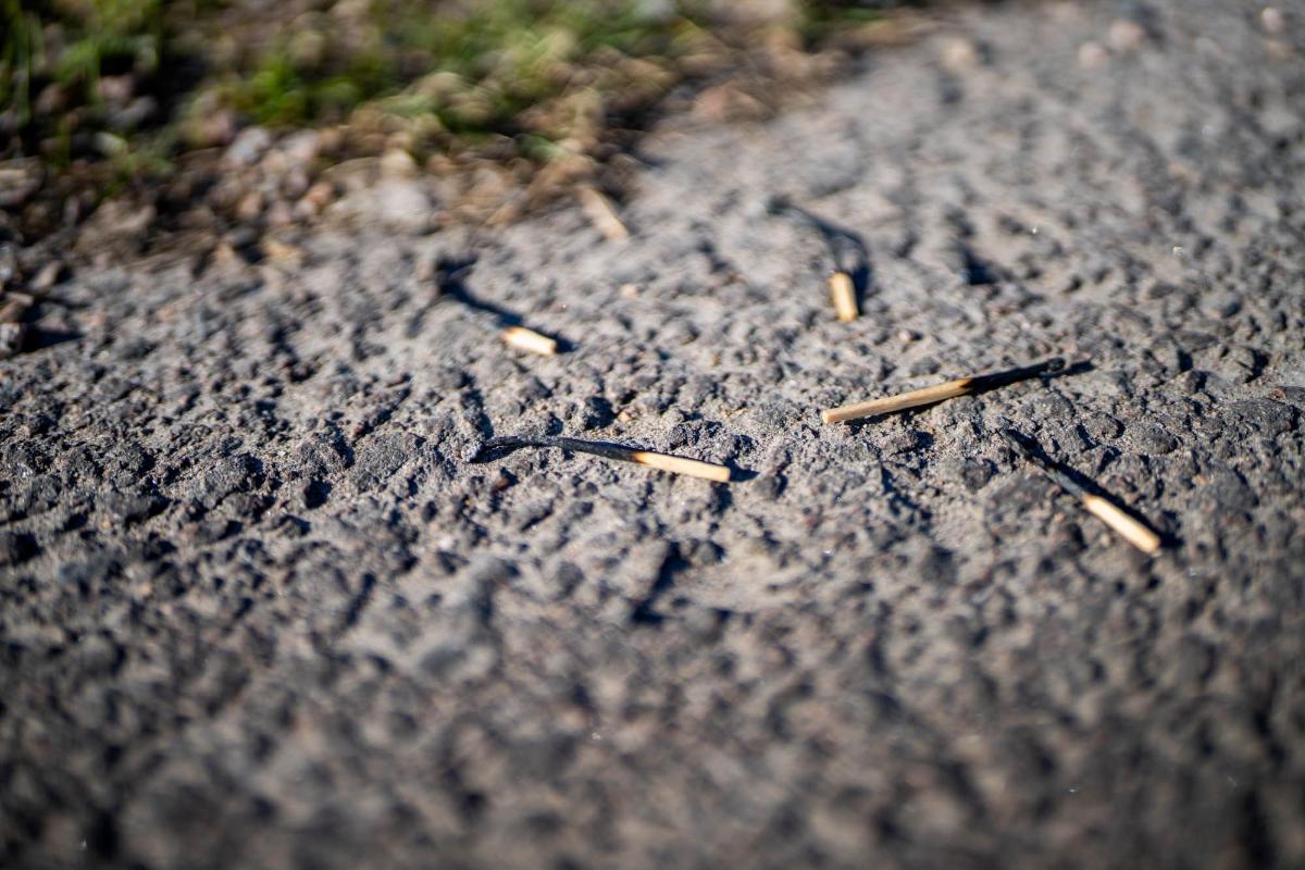 Palaneita tulitikkuja asfaltilla.