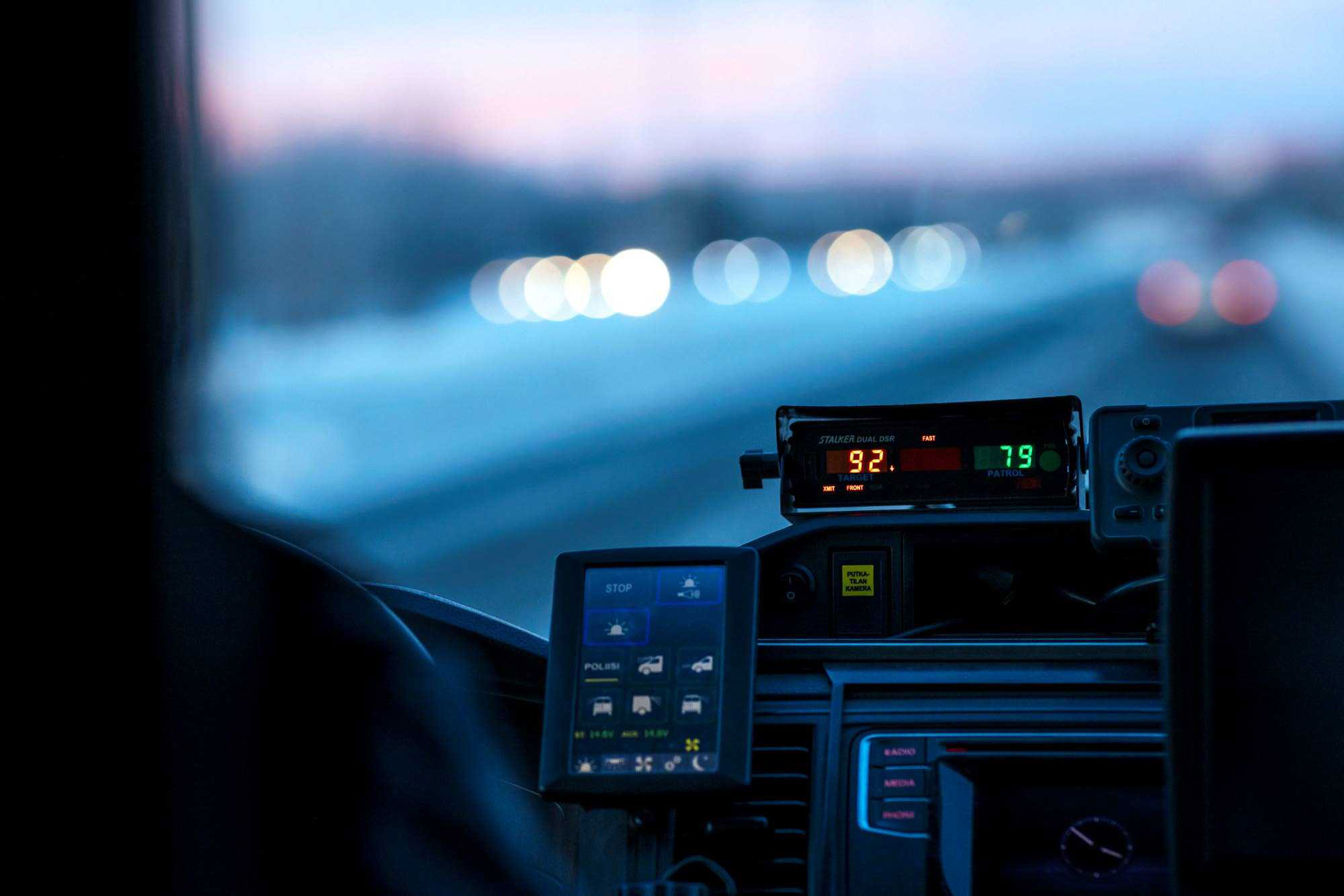 A radar speed gun in operation inside a police car with the speed readings visible. 