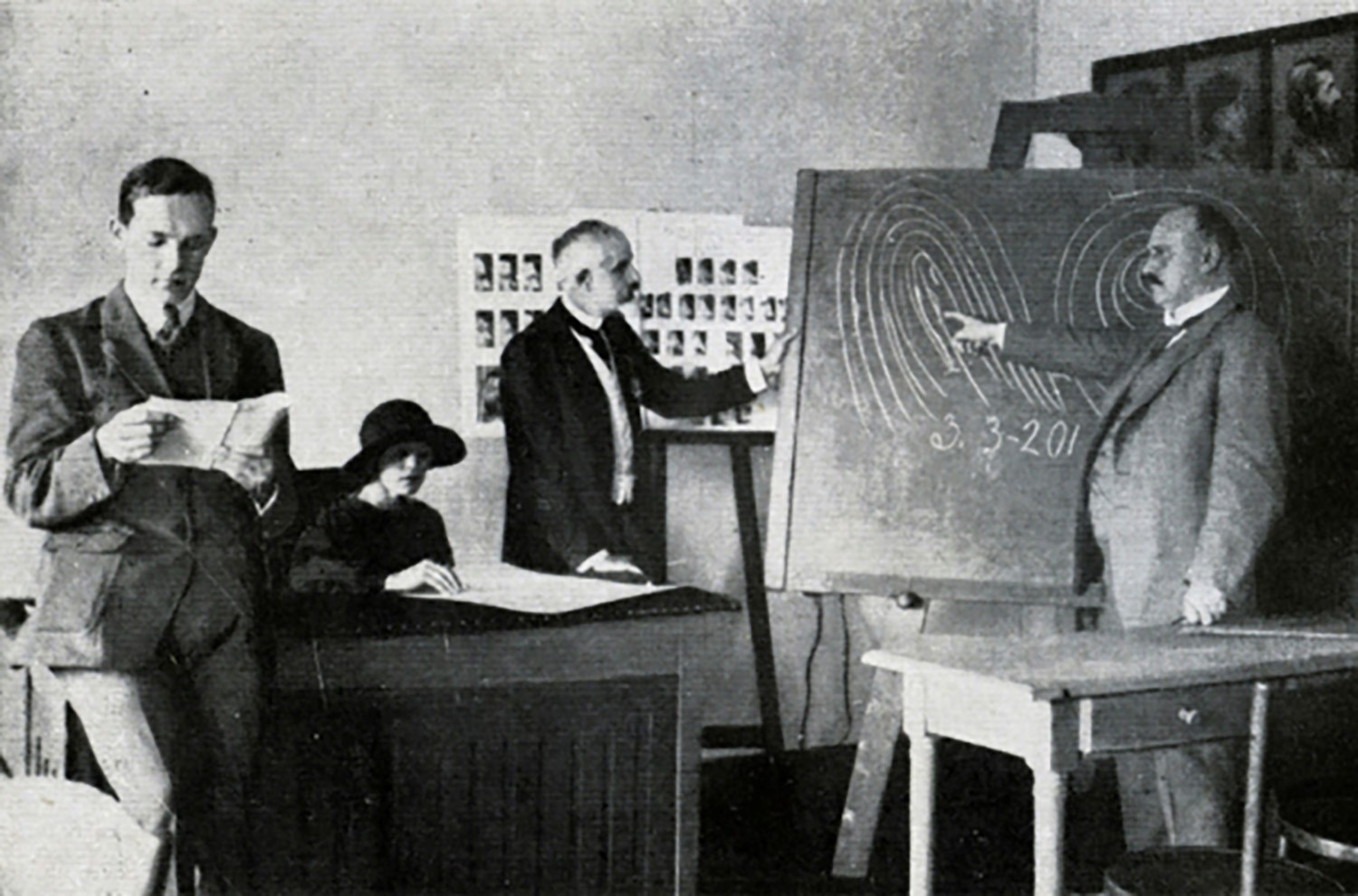 In the foreground, a man is reading a newspaper. In the background, a woman with a hat at a table and two men in front of a blackboard. Images of fingerprints are drawn on the board.