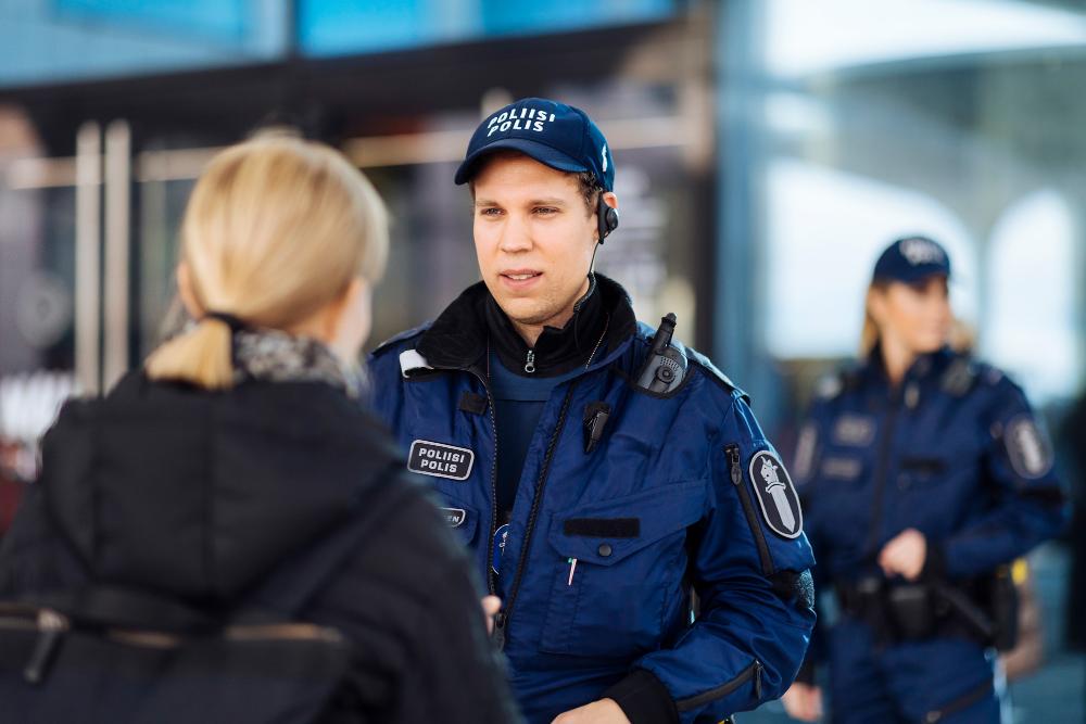 Police in uniform talking to a woman.