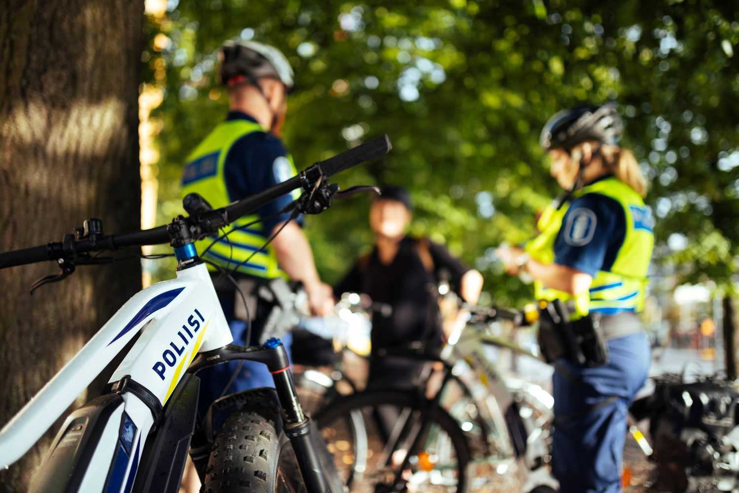 Cykelpoliser pratar med kunden. Poliscykel i förgrunden.ä.