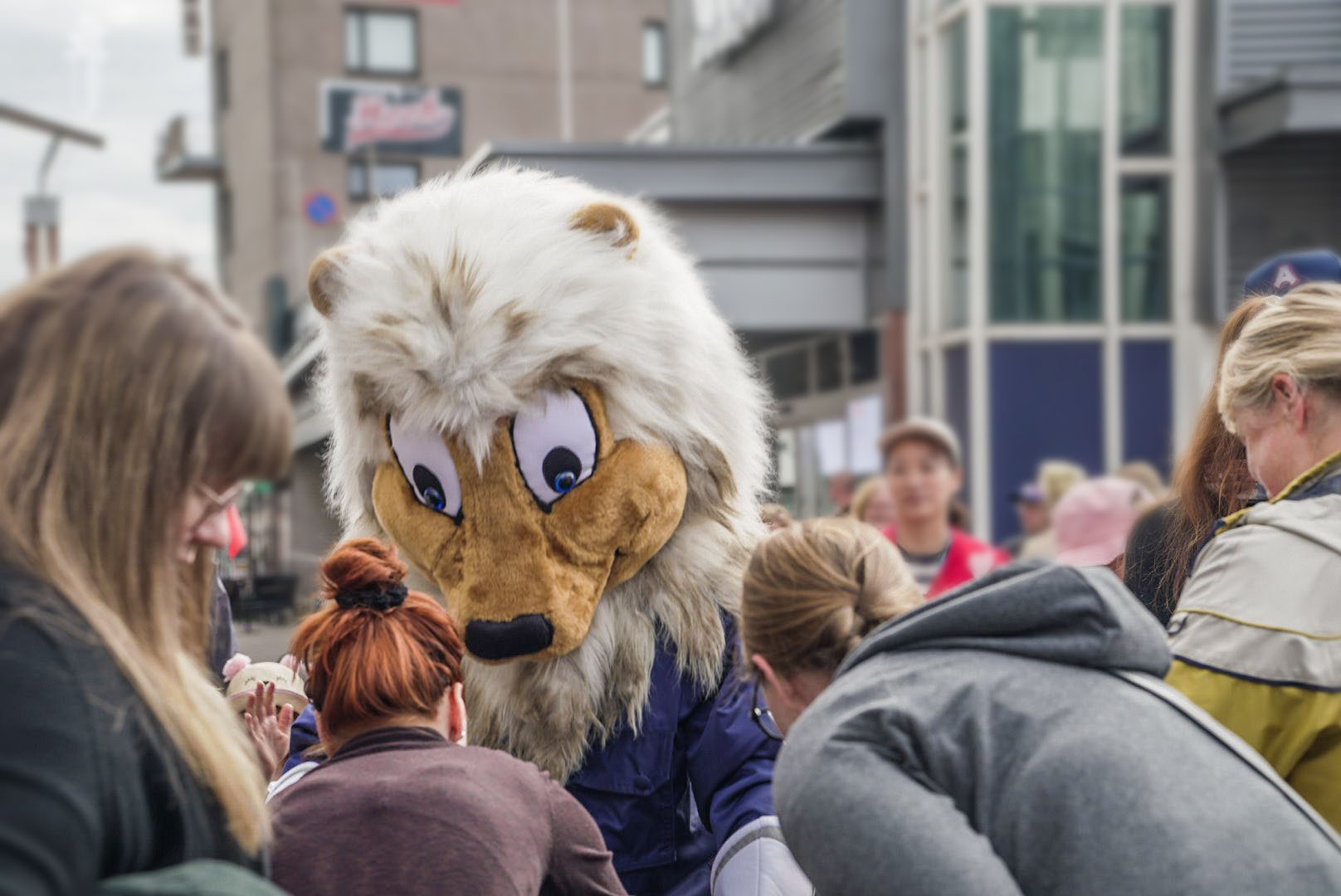 Poliisileijona tervehtimässä lapsia Poliisin päivän tapahtumassa.