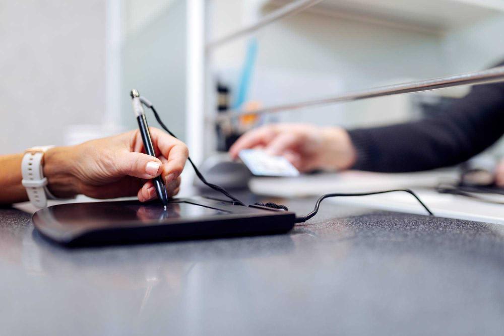 Asiakas allekirjoittaa sähköisesti poliisin lupapalvelupisteellä.