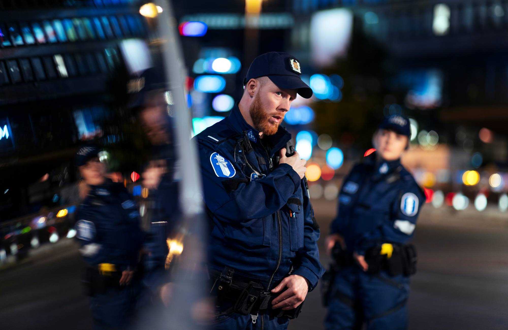 Kaksi poliisia Helsingin keskustassa yollä elokuussa 2020 poliisiauton edustalla.