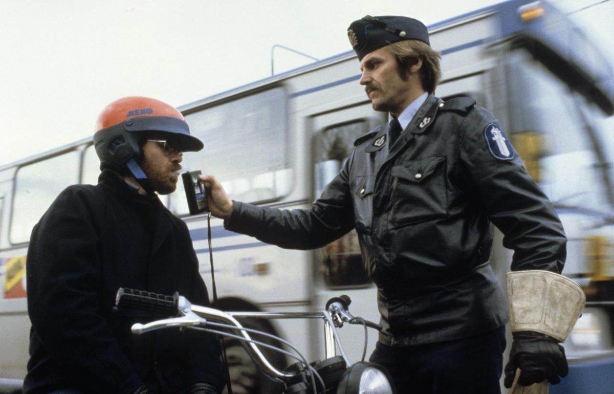 Poliisi puhalluttaa mopon kuljettajaa alkometrillä.