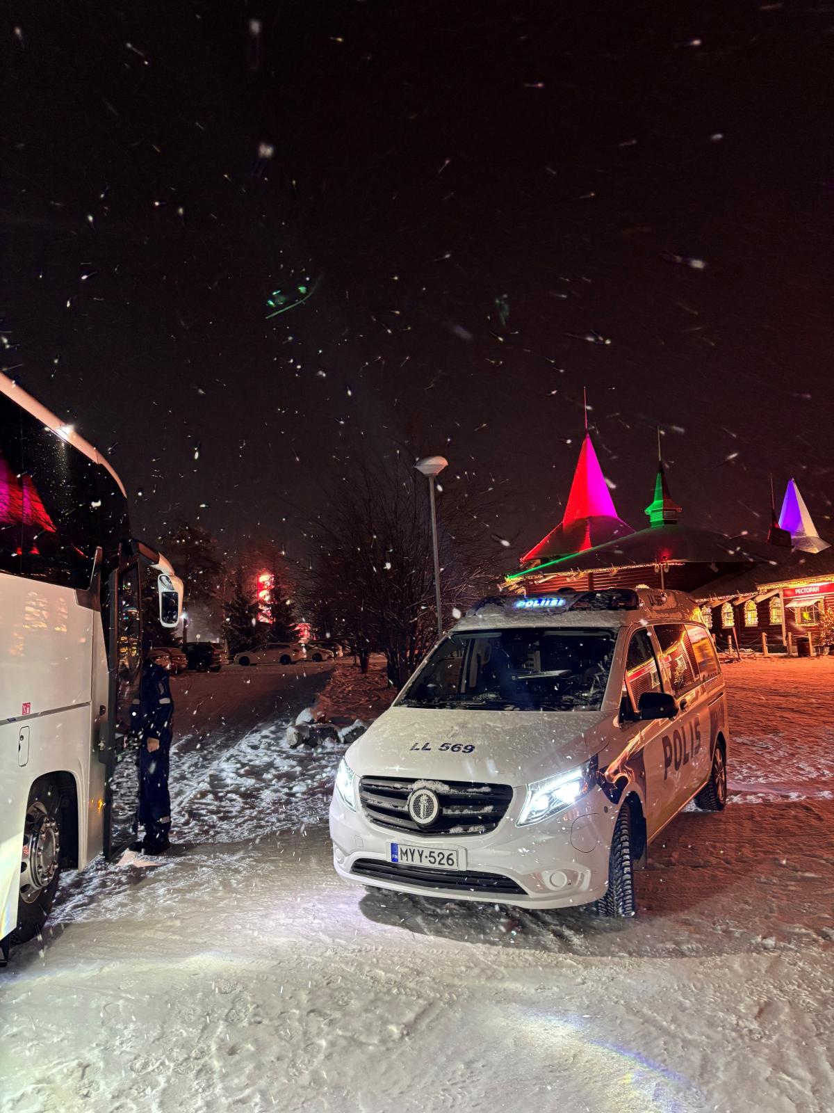 Poliisiauto linja-auton vierellä valvontatilanteessa talvisessa maisemassa