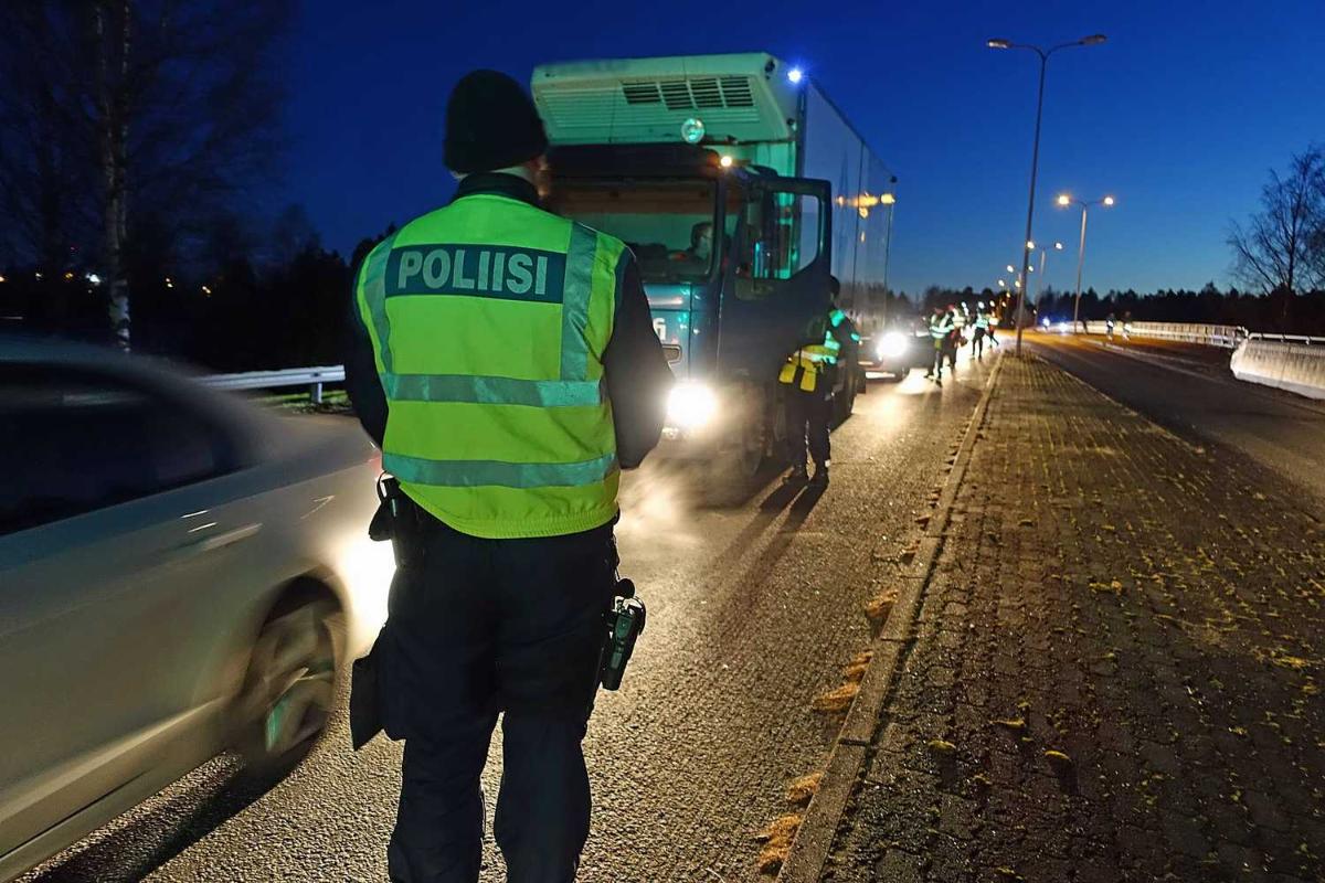Hämärä vuodenaika. Tiellä ajoneuvoja jonossa ja poliisi pysäyttämässä niitä.