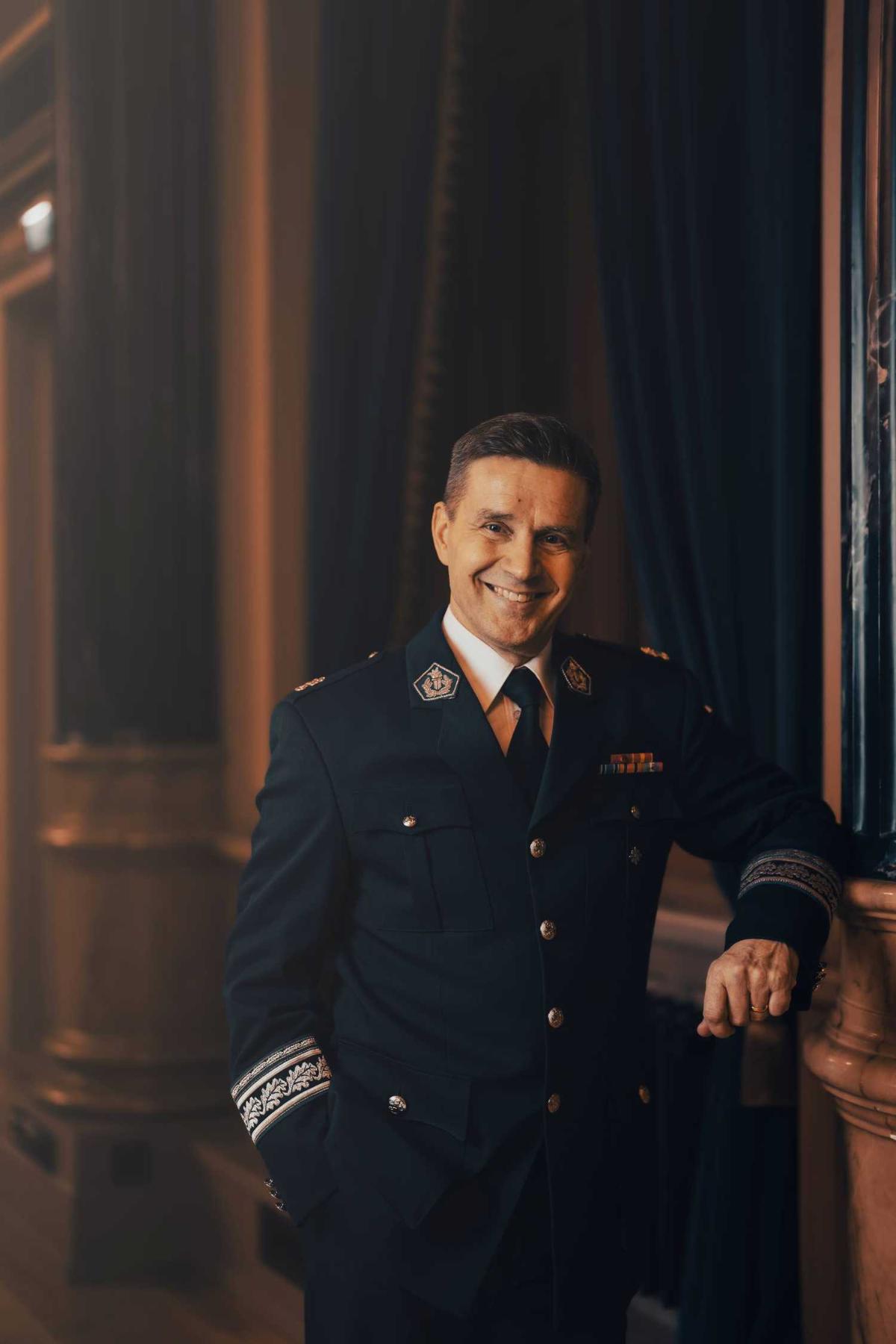 Mies poliisin uniformussa. Tummahko kuva.