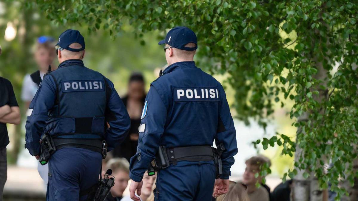 Två poliser går bland folkmassa på sommaren.