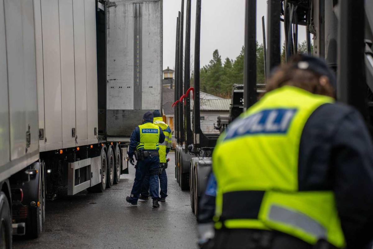 Isoja ajoneuvoja ja niiden välissä kolme virkamiestä keltaisissa liiveissä. Etummaisella lukee liivissä Tulli.