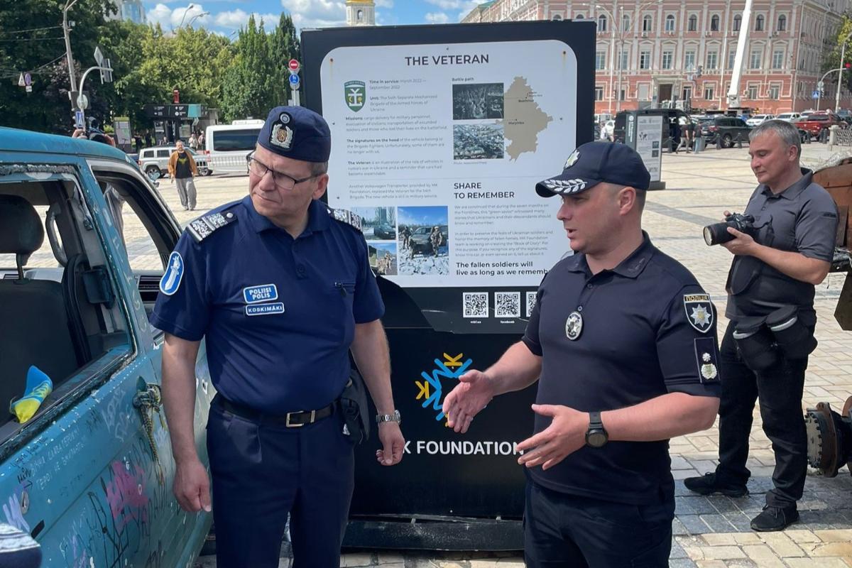 Poliisiylijohtaja Ilkka Koskimäki ja Ukrainan kansallisen poliisin päällikkö Ivan Vyhivskyi katsovat tuhottua ajoneuvoa Kiovassa sijaitsevalla aukiolla.