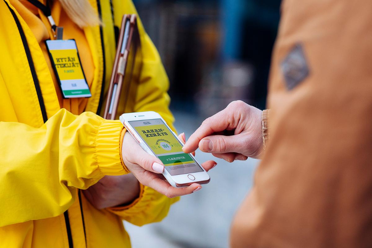 The picture shows a mobile phone and two people on the street.