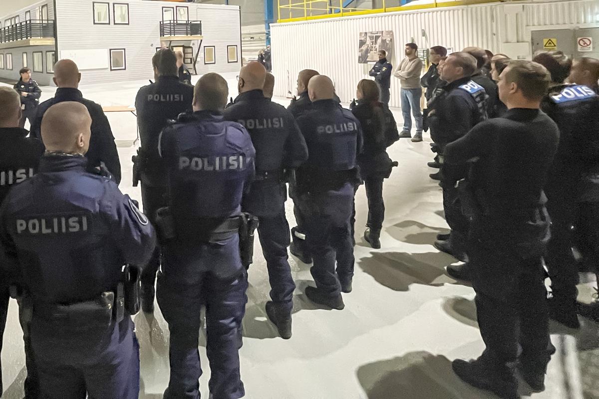 Flera poliser står och tittar bort.