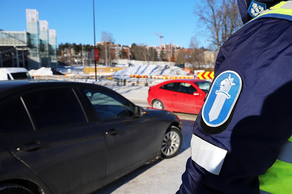 Poliisimies valvoo liikennettä talvipäivänä tien laidalla Espoossa