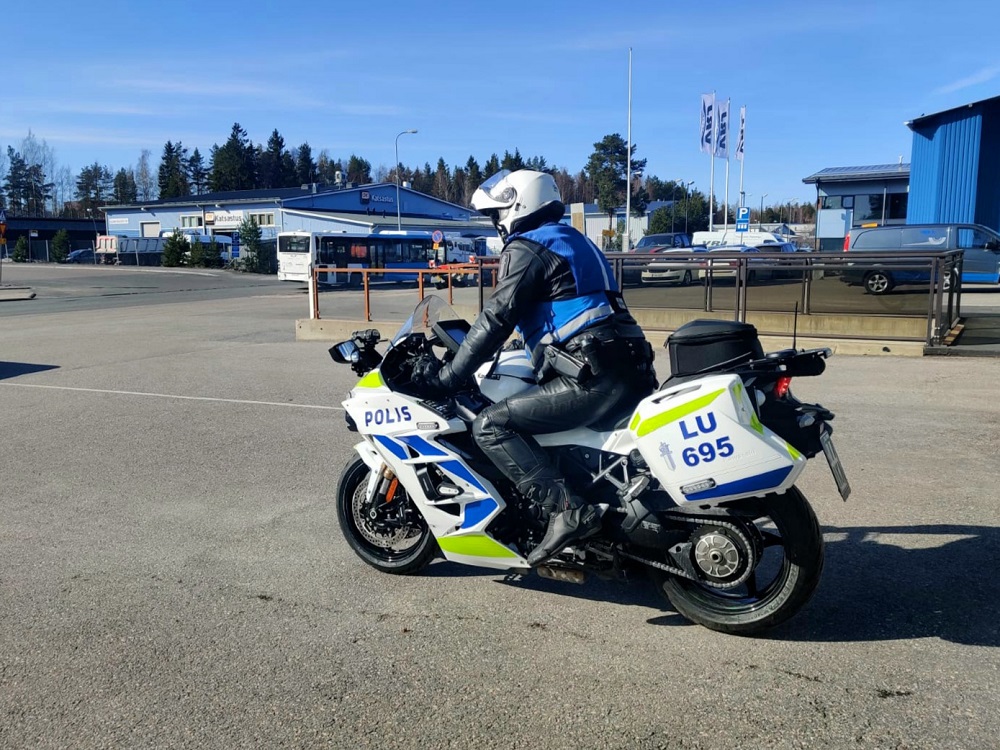 En motorcykelpolis startar sin motorcykel från en parkeringsplats.