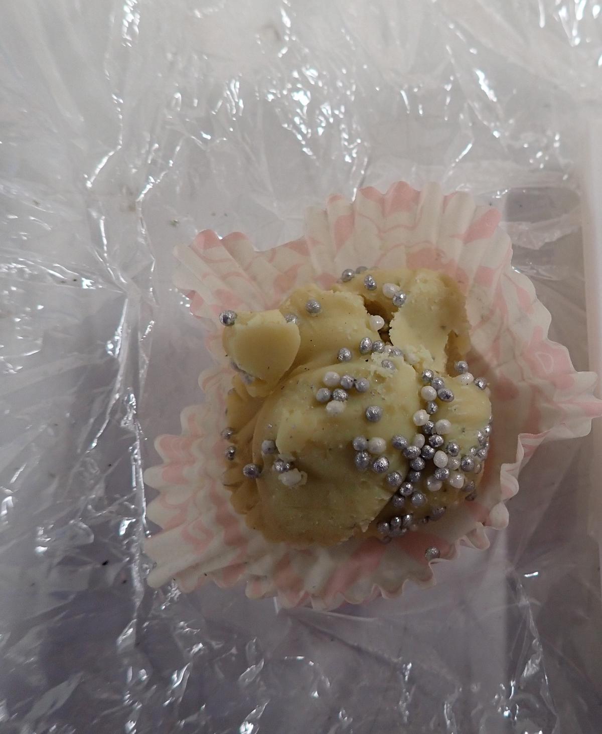 Läpinäkyvään muoviin pakattu muffinssivuoassa oleva vaaleankeltainen marihuanaa sisältävä leivos.
