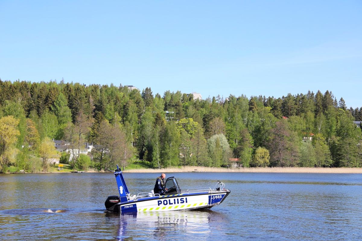 Poliisi ajaa poliisiveneellä järvellä.