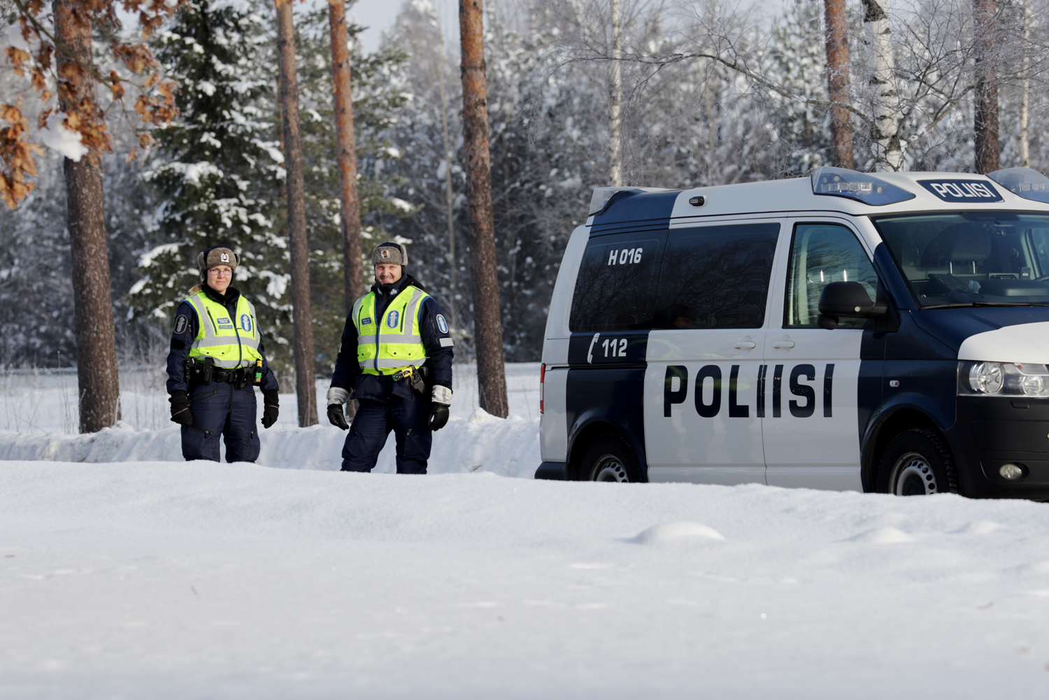 Polispatrull brevid en polisbil på en vacker vinterdag.