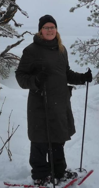 Kuvassa naisella yllä tumma pitkä ulkotakki