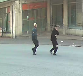 Kaksi miestä juoksevat kadulla