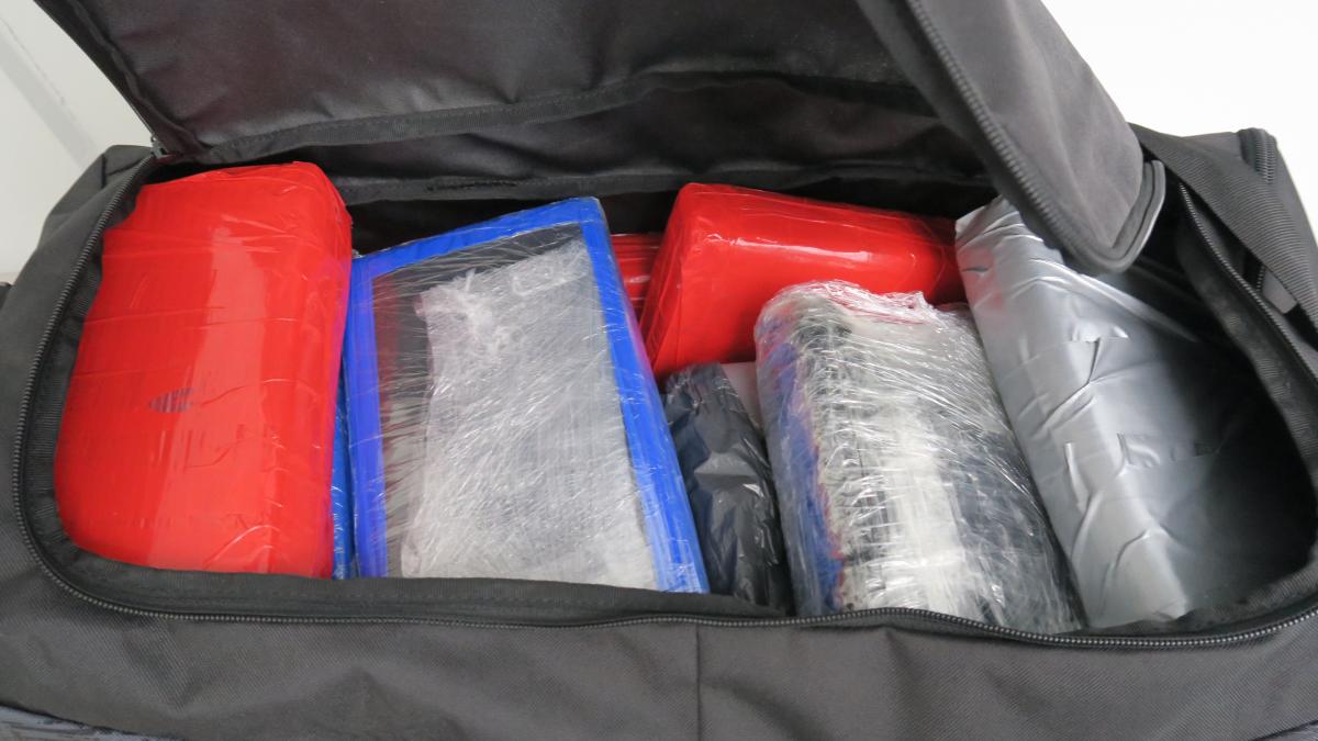 kuvassa on musta laukku, jonka sisällä pakattuja kokaiiniharkkoja