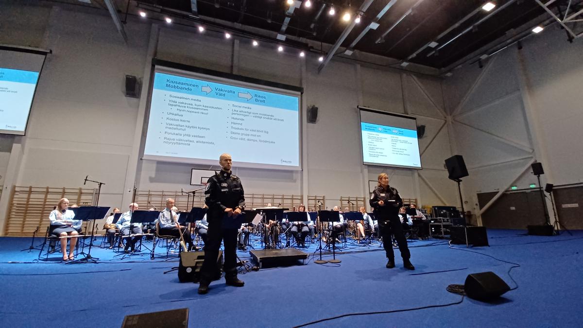 Kaksi poliisia puhuu orkesterin ja esityksen edustalla.