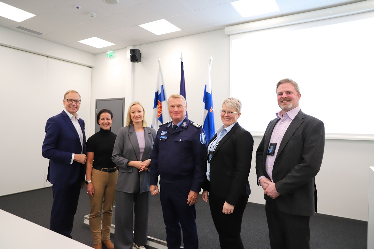 Poliisin ja kuntien edustajia seisoo rivissä auditoriossa.