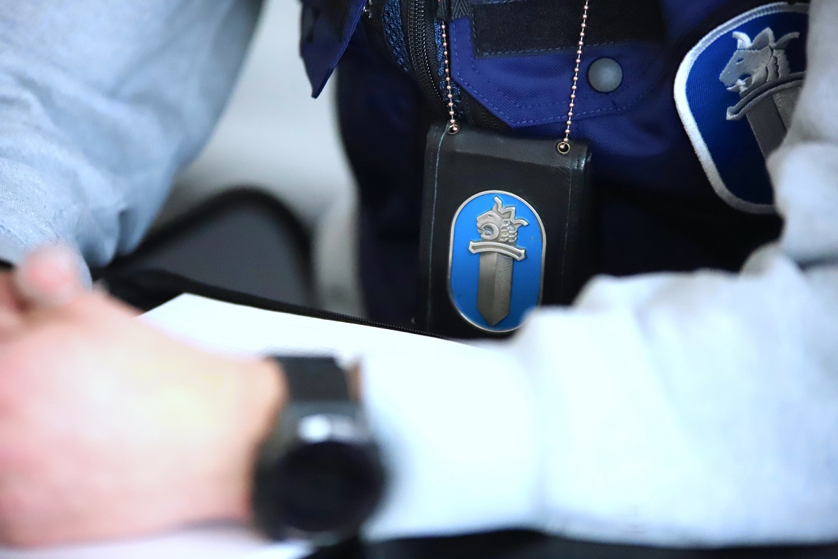 Rikostutkija, jolla roikkuu kaulassaan poliisimerkki.