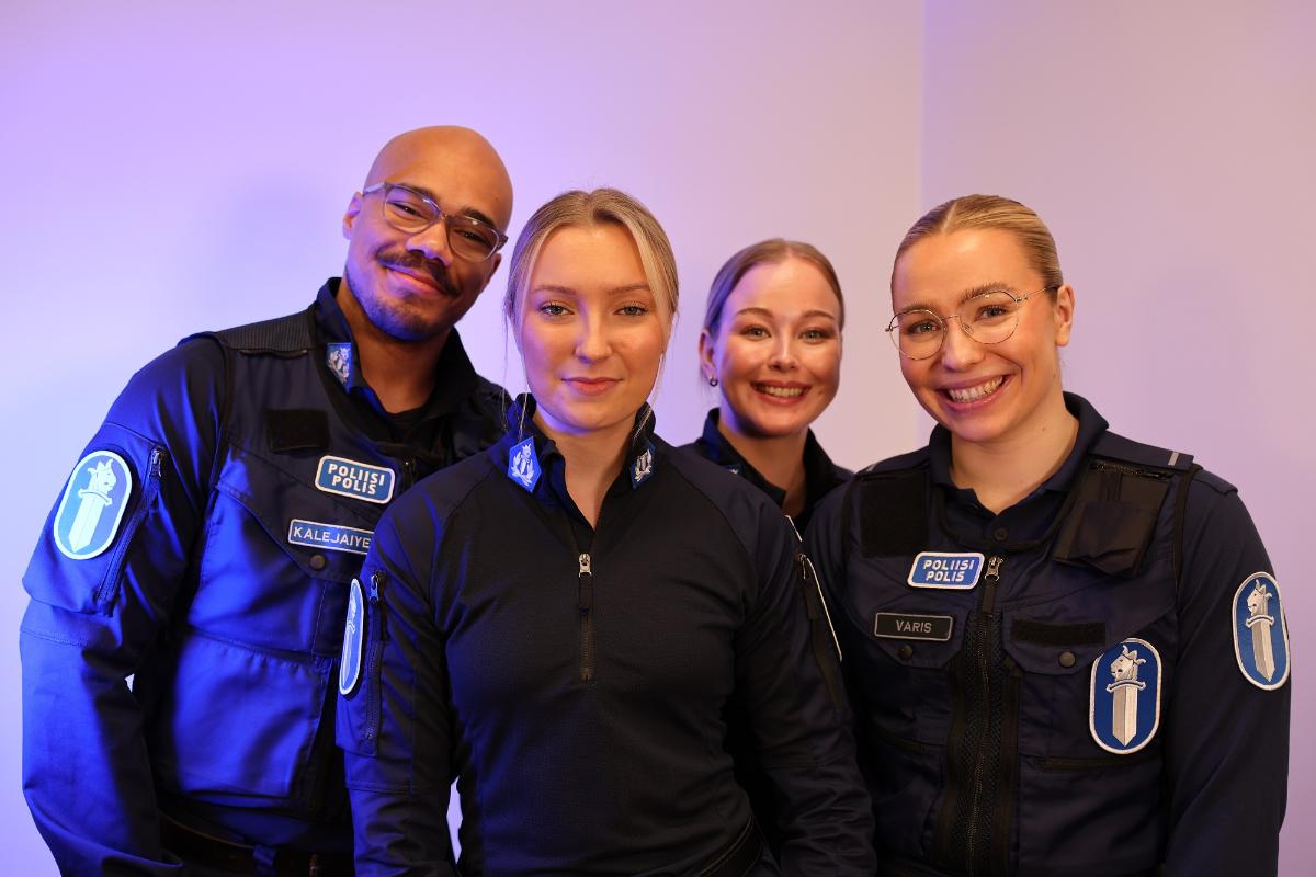 Miespoliisi ja kolme naispoliisia seisovat vierekkäin.