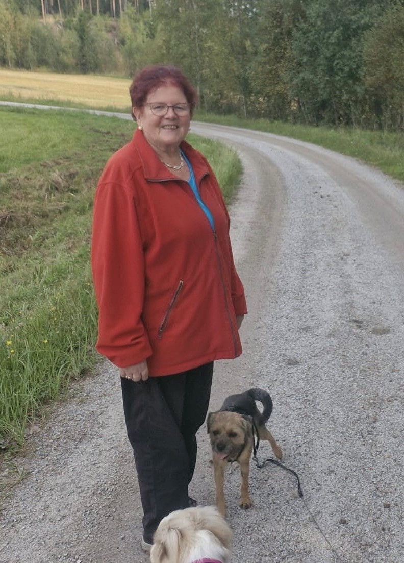 Kuvassa kadonnut nainen hiekkatiellä kävelemässä koirien kanssa.