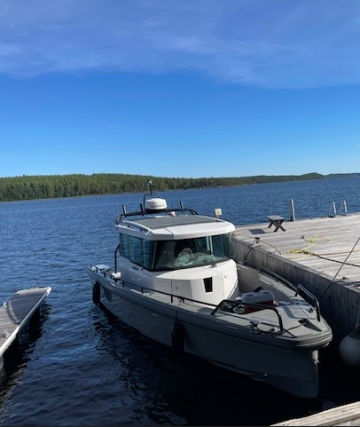 Harmaa vene kiinni laiturissa.