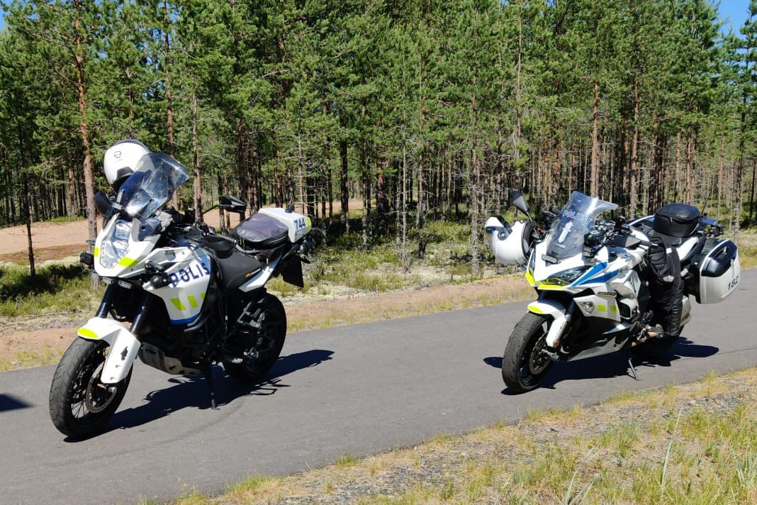 Kaksi poliisin moottoripyörää asfalttitiellä.