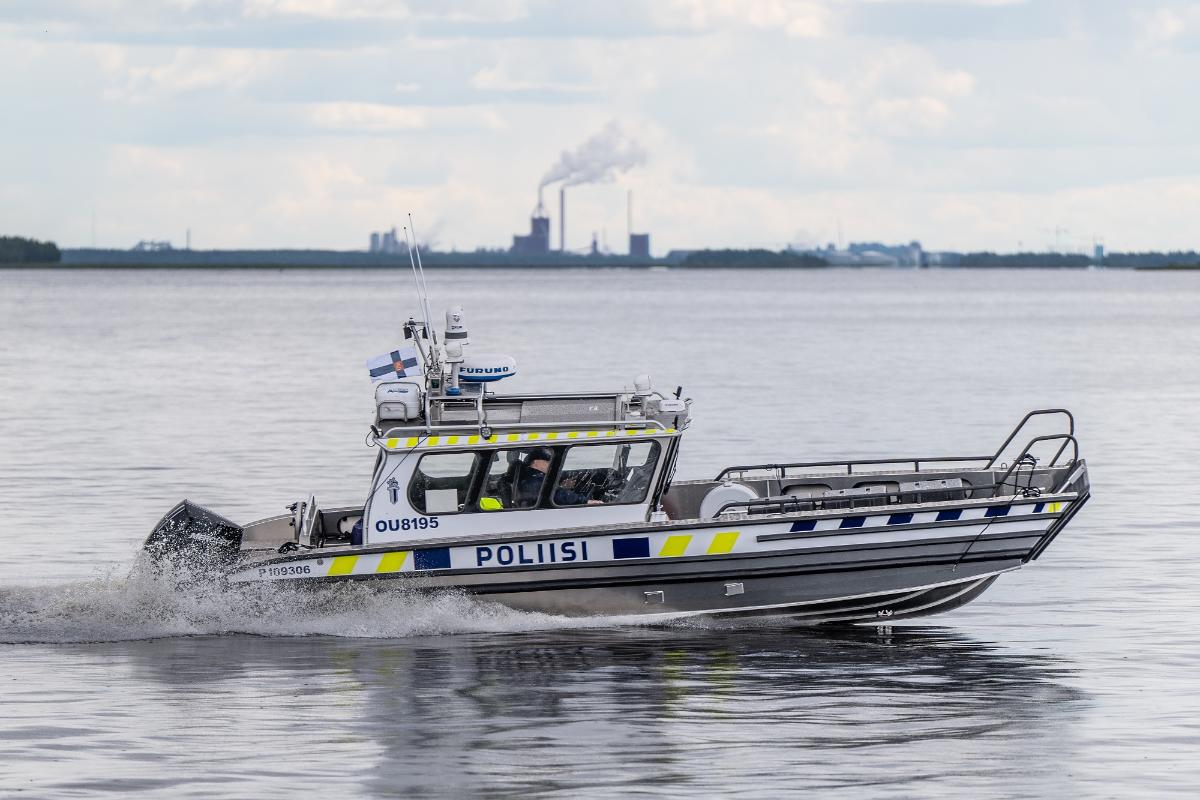 Poliisivene vesillä, taustalla tehdas