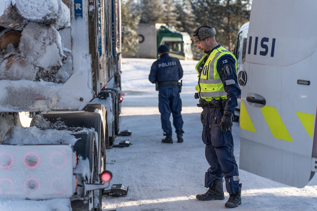 Poliisi tarkastelee raskasta ajoneuvoa kirkkaana talvipäivänä.