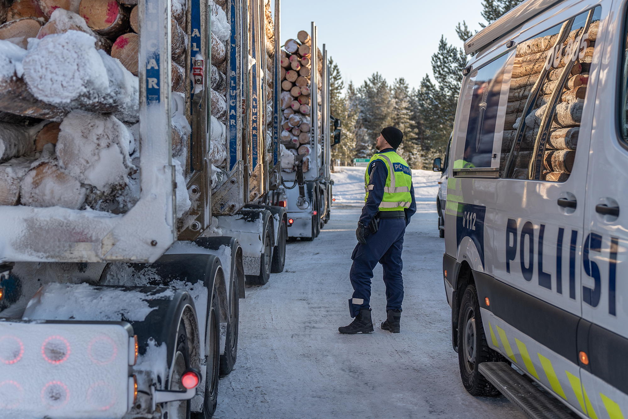 Poliisi tarkastelee raskasta ajoneuvoa kirkkaana talvipäivänä.
