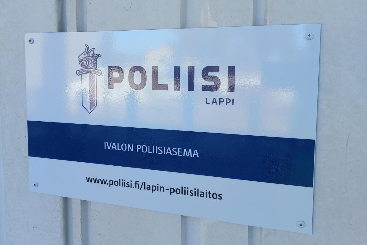 Lähikuva seinään kiinnitetystä opasteesta, jossa näkyvät poliisin logo, tekstit 