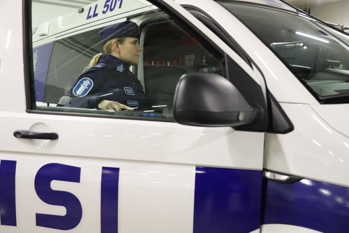 Naispoliisi on astumassa poliisiautoon.