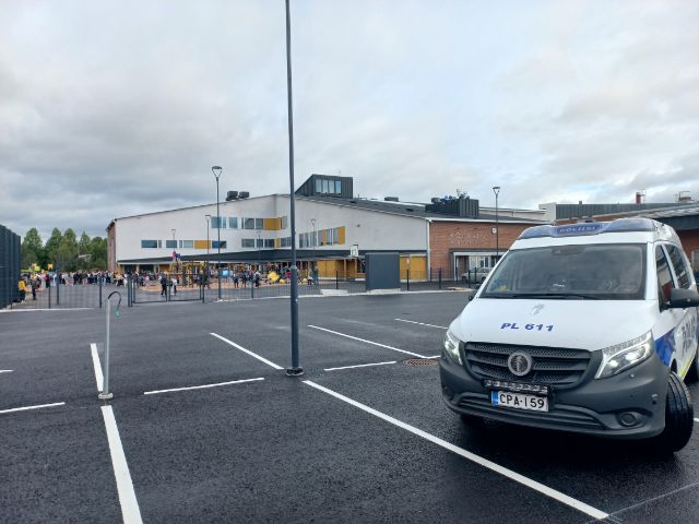 Poliisiauto on pysäköity koulun parkkialueelle