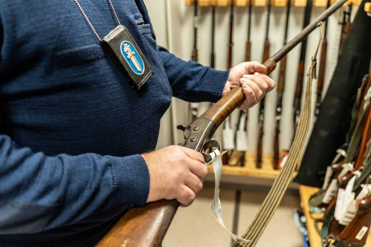 Poliisimies pitää asetta kädessään