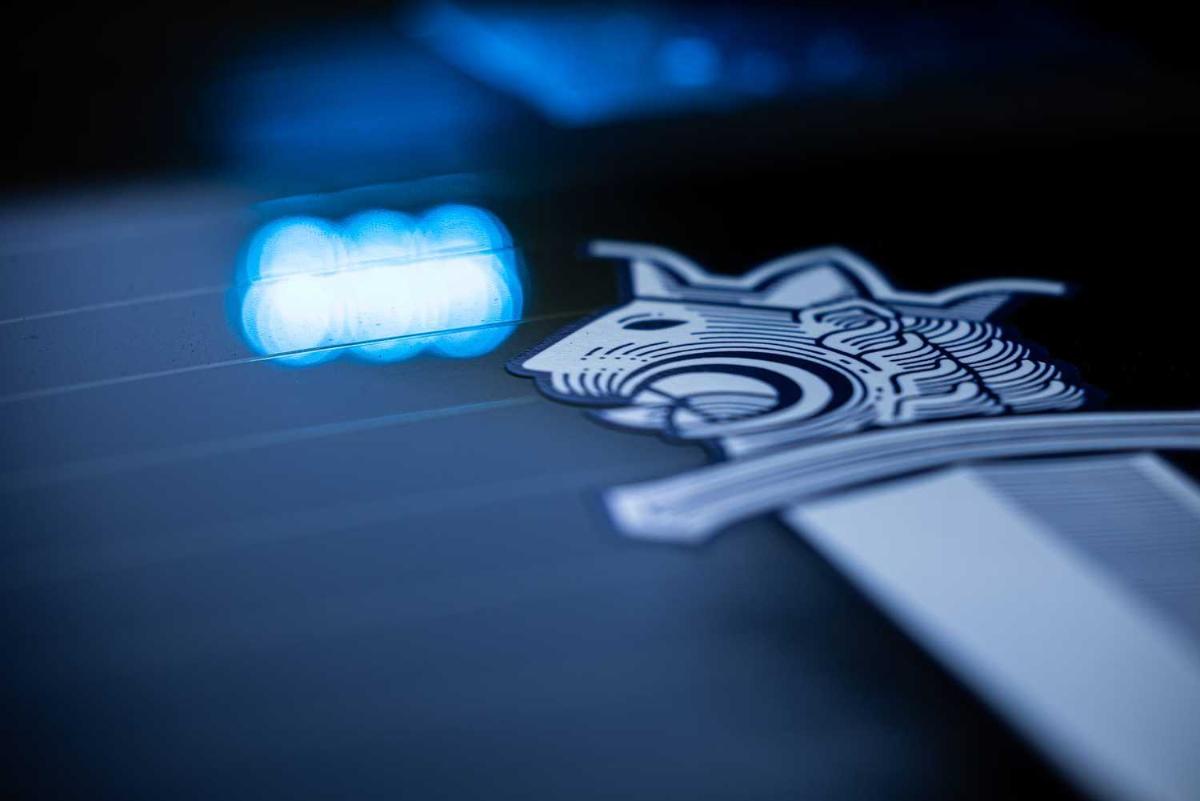 Poliisin miekkaleijona tarra auton ikkunassa sekä valojen heijastuma