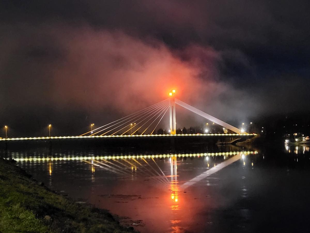 Rovaniemen Jätkänkynttilän sillan merkkivalo kajastaa punaisena yön usvassa