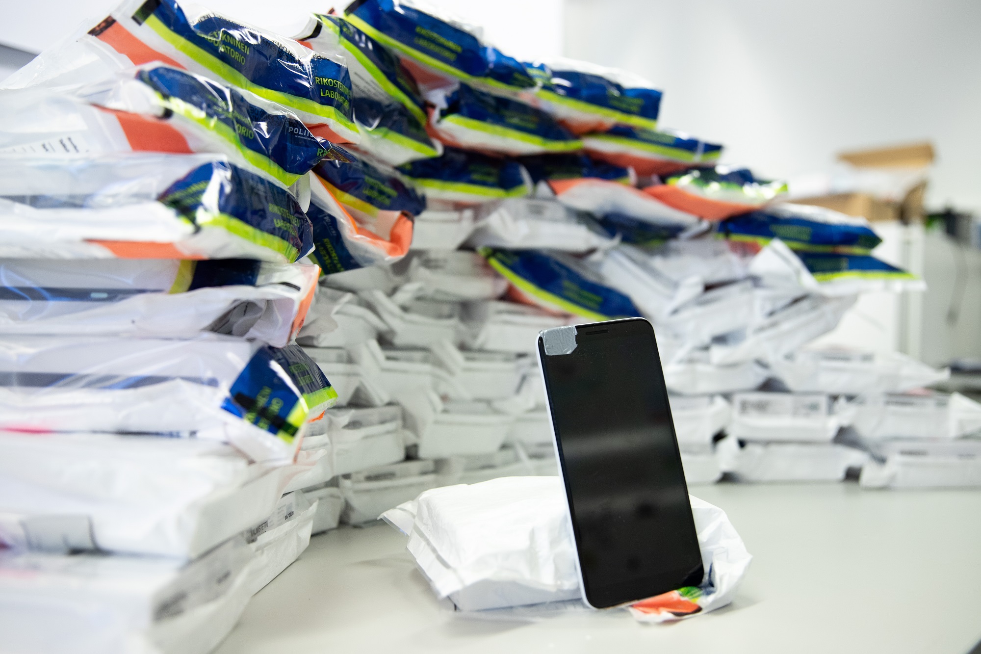 Alt: Phones seized by the police in sample bags bearing the name Forensic Laboratory.