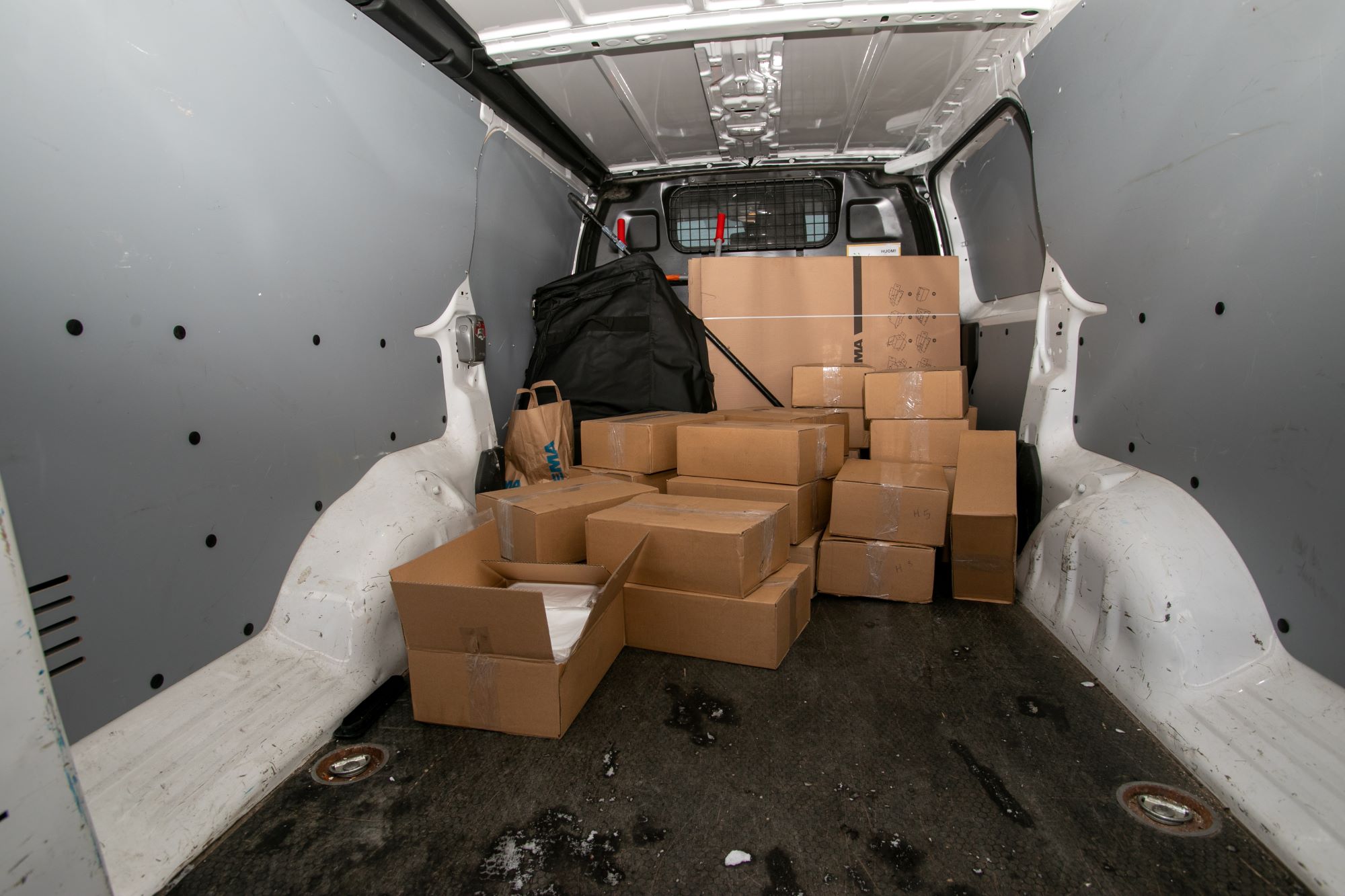 Amfetamiinia ja hasista sisältävät pahvilaatikot pakettiauton tavaratilassa. Kuva: Keskusrikospoliisi.