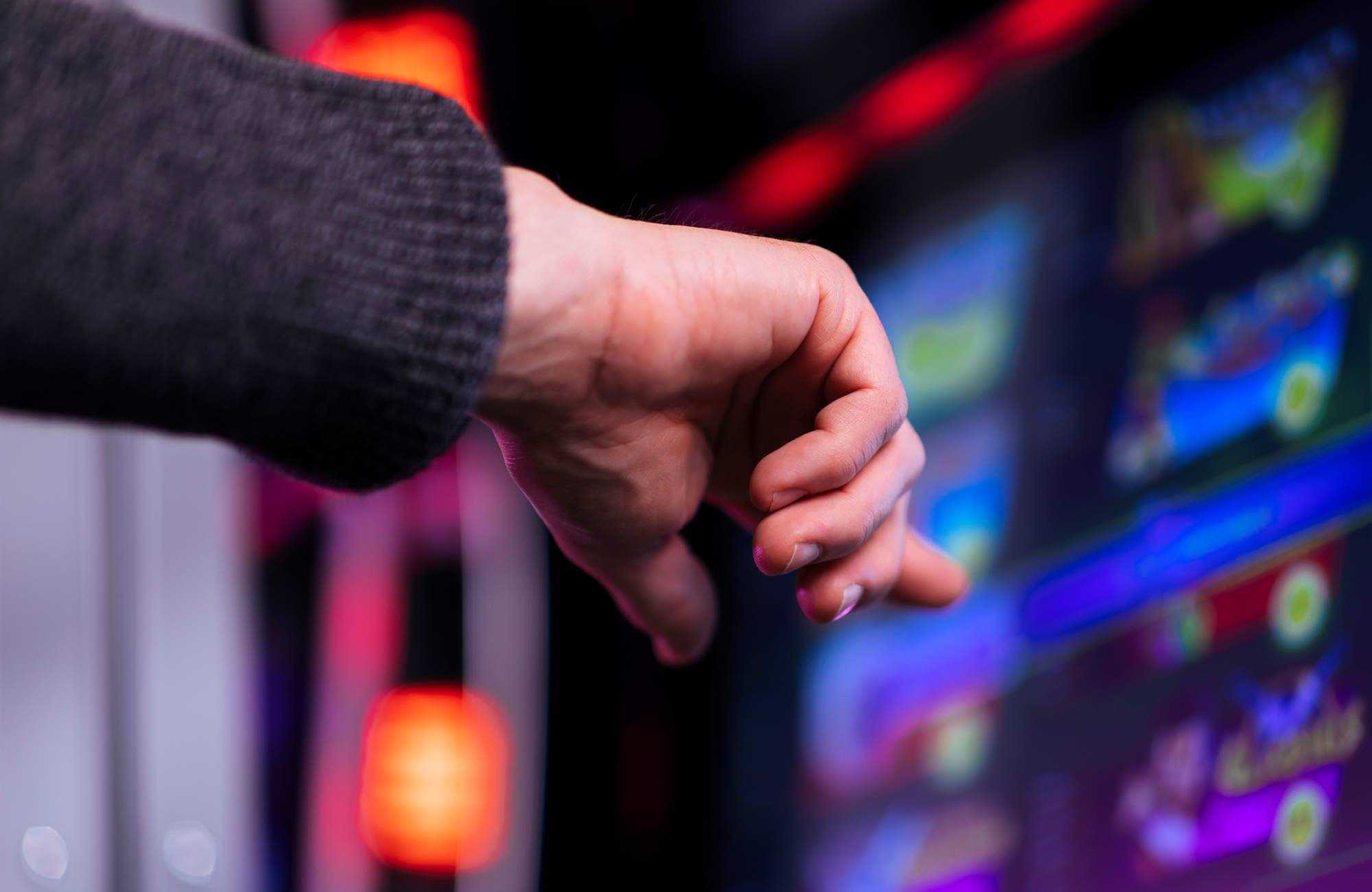Ett finger pekar på skärmen av en spelautomat.