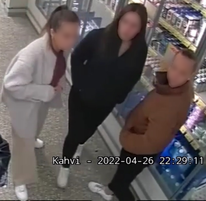 Kolme naista kylmäkaapin edessä kaupassa.