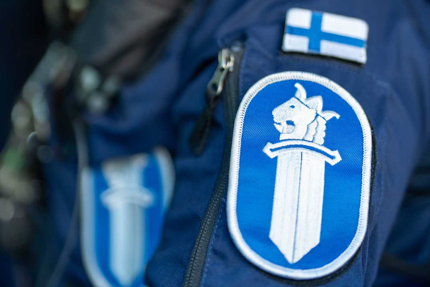 Polisens svärdemblem på uniformens ärm.