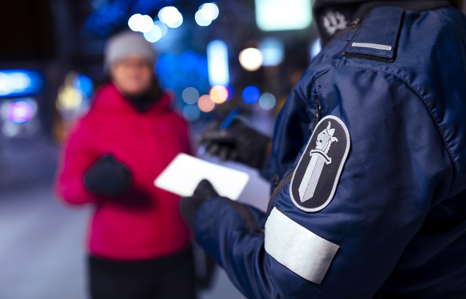 A uniformed police officer takes notes from a customer.