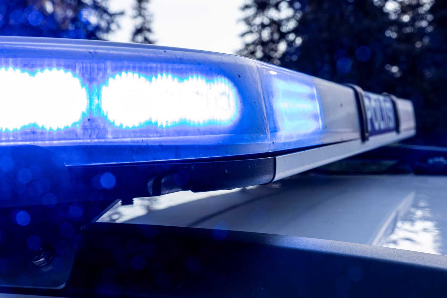 The police car has a blue emergency light switched on in the roof light panel.